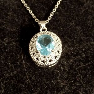 Blue topaz color stone necklace in an oval pendant.